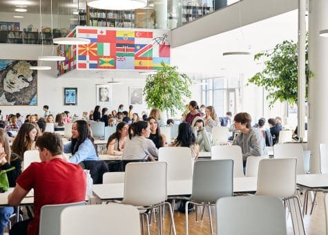 photo of students in the cafeteria with the library above them