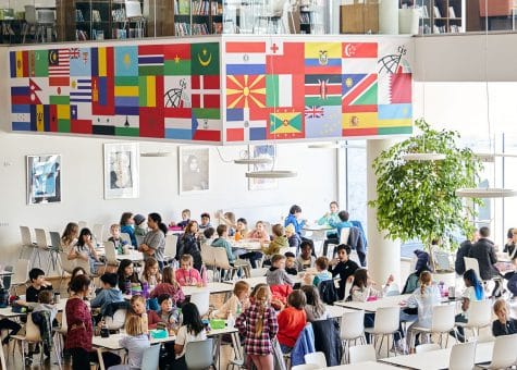 photo of students in the cafeteria with the library above them