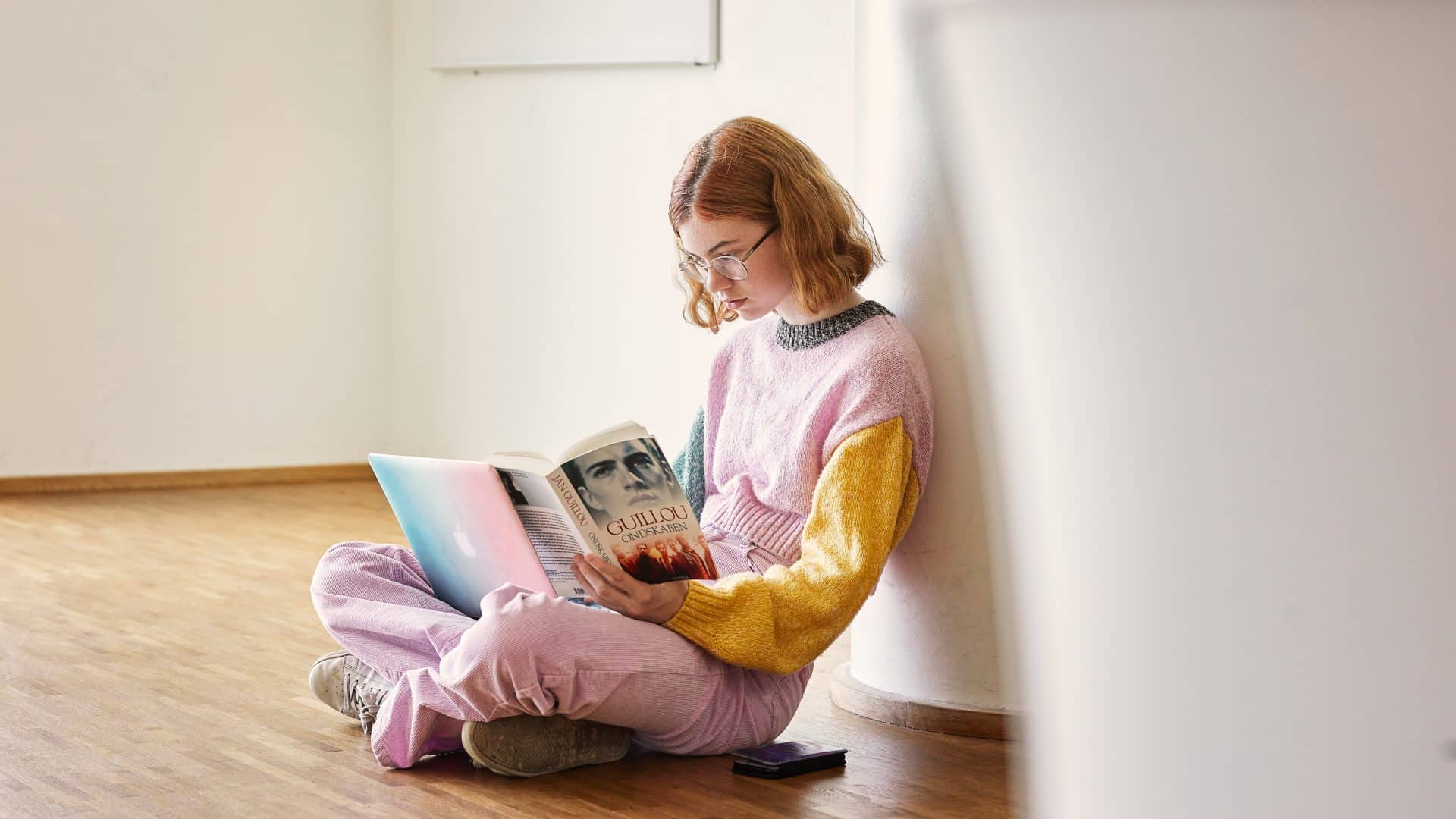 CIS student sitting and reading a book