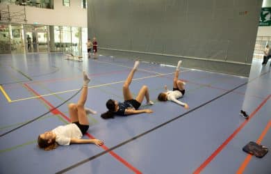 students doing gymnastics dance in gym